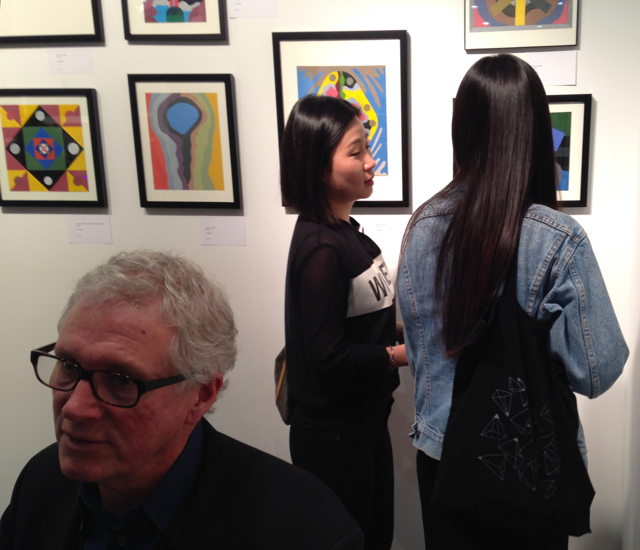Visitors discussing the paintings of Larry Palsson